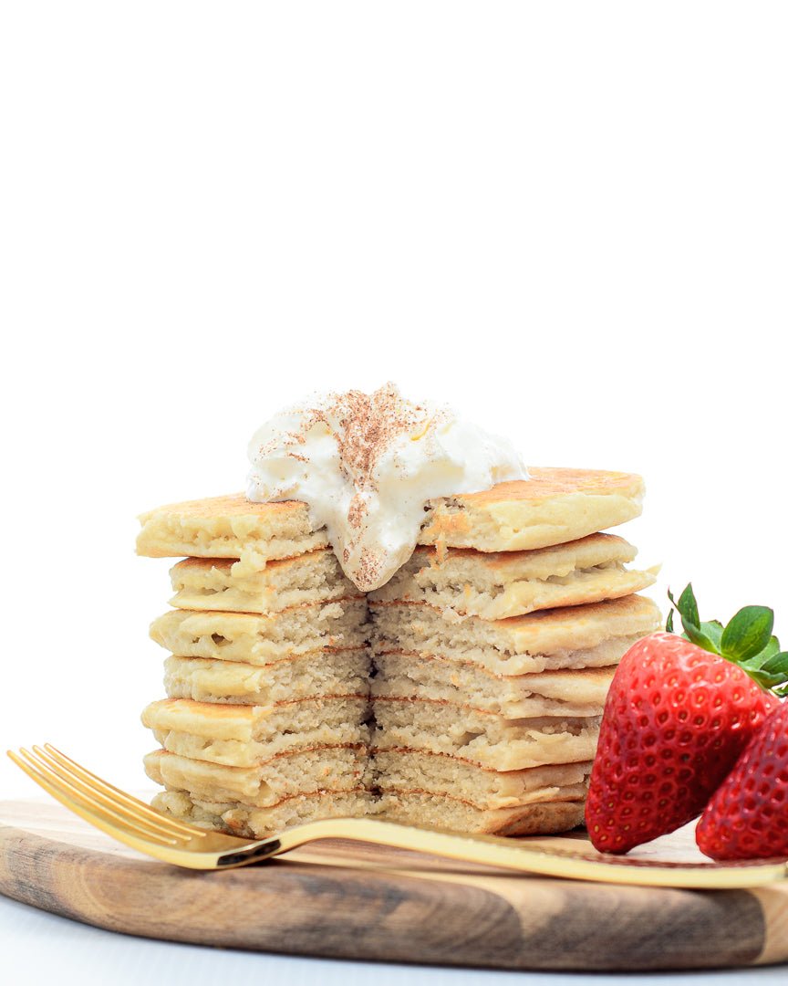 Stack of cinnamon pancakes with whipped cream and strawberries